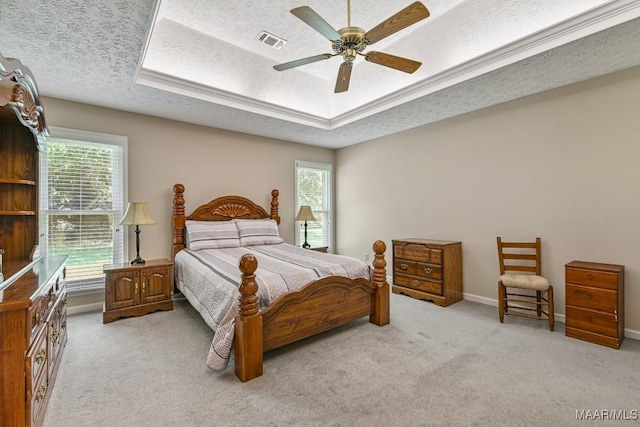165 Ten Cedars Dr, Titus, AL 36080 - bedroom with multiple windows, a textured ceiling, a tray ceiling, and light colored carpet