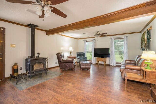 1352 Gibson Rd, Greenville, AL 36037 - living area with a ceiling fan, crown molding, wood finished floors, a wood stove, and beam ceiling