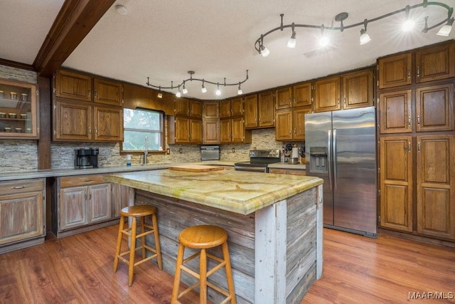 1352 Gibson Rd, Greenville, AL 36037 - kitchen with appliances with stainless steel finishes, light countertops, wood finished floors, and decorative backsplash