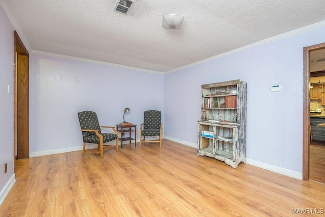 1352 Gibson Rd, Greenville, AL 36037 - living area featuring light wood-style floors, crown molding, and a textured ceiling
