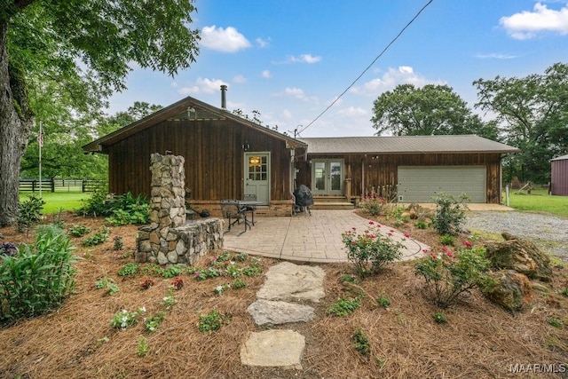 1352 Gibson Rd, Greenville, AL 36037 - back of house with french doors, gravel driveway, a garage, entry steps, and a patio area