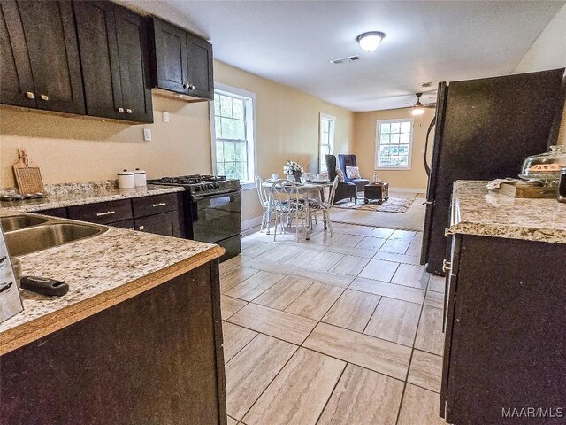 530 W 4th St, Prattville, AL 36067 - kitchen with black range with gas stovetop, ceiling fan, open floor plan, and dark brown cabinets