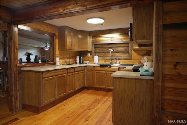 2044 Williamson Rd, Luverne, AL 36049 - kitchen with light wood finished floors, light countertops, brown cabinetry, and wooden walls