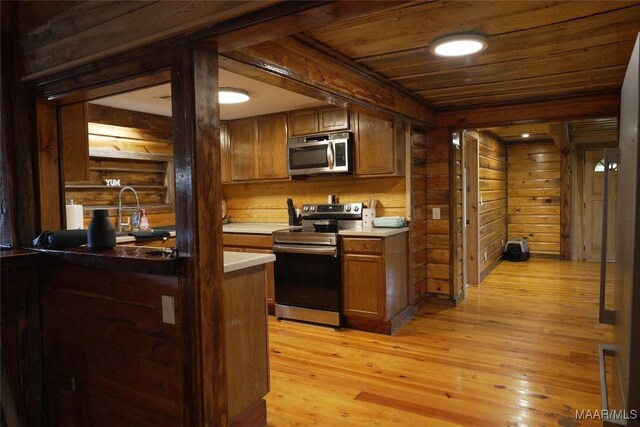 2044 Williamson Rd, Luverne, AL 36049 - kitchen with stainless steel appliances, wood walls, wood ceiling, light wood-style floors, and brown cabinetry