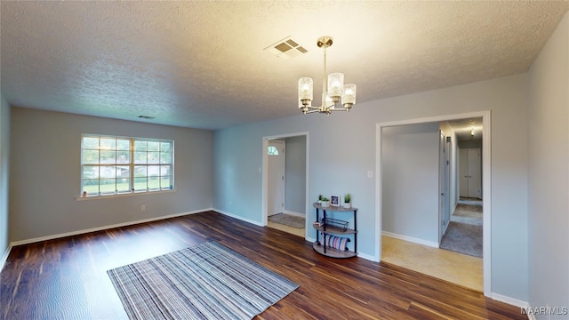 461 Glade Park Dr, Montgomery, AL 36109 - spare room with dark wood-style flooring, a textured ceiling, and a chandelier