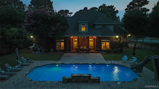 7025 Wynlakes Blvd, Montgomery, AL 36117 - pool at dusk with a water slide, a patio area, and a yard