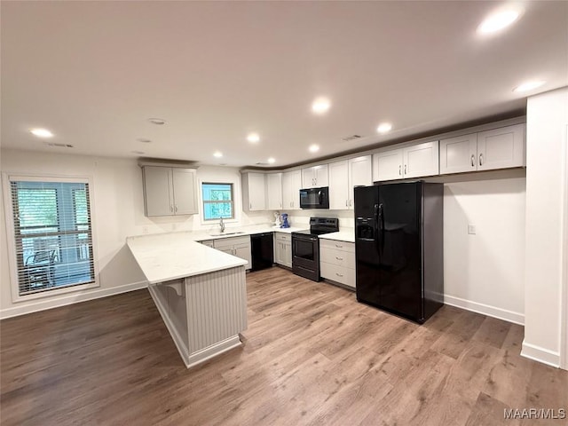 201 Greencrest Ln, Prattville, AL 36067 - kitchen with black appliances, a peninsula, light countertops, recessed lighting, and light wood-type flooring