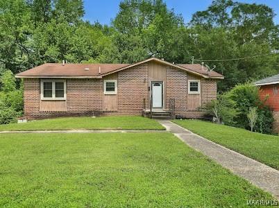 1219 First Ave, Tuskegee, AL 36088 - view of front of property featuring brick siding, a front lawn, and entry steps