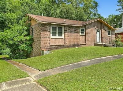 1219 First Ave, Tuskegee, AL 36088 - ranch-style home featuring brick siding and a front lawn