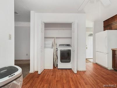 1219 First Ave, Tuskegee, AL 36088 - laundry area featuring washer / clothes dryer, wood finished floors, and ceiling fan