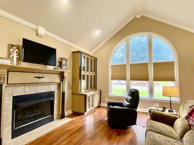 1210 Sadie Cir, Prattville, AL 36066 - living area featuring wood finished floors, a tile fireplace, vaulted ceiling, and crown molding