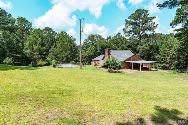 1245 Providence Rd, Titus, AL 36080 - view of green lawn featuring a carport, an outdoor pool, and a wooded view