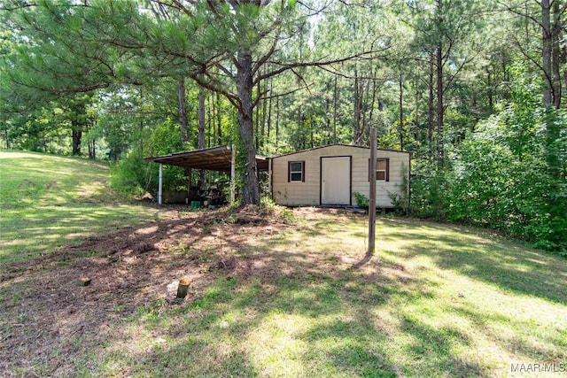 1245 Providence Rd, Titus, AL 36080 - view of grassy yard with a storage unit, a carport, and a wooded view