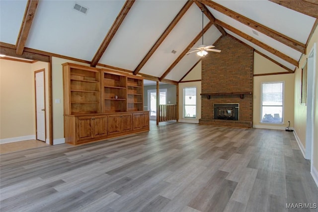 1245 Providence Rd, Titus, AL 36080 - unfurnished living room featuring high vaulted ceiling, a ceiling fan, beamed ceiling, a fireplace, and plenty of natural light