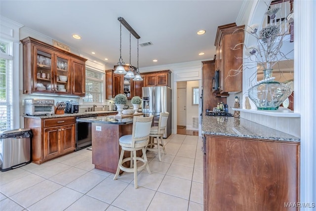 742 Mckeithen Pl, Millbrook, AL 36054 - kitchen featuring stainless steel appliances, dark stone counters, light tile patterned floors, a breakfast bar area, and ornamental molding
