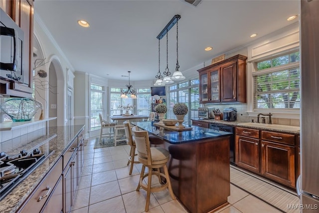 742 Mckeithen Pl, Millbrook, AL 36054 - kitchen featuring black appliances, tasteful backsplash, a kitchen island, dark stone counters, and a breakfast bar