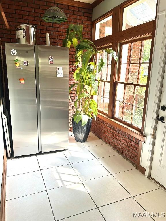 309 Broad St, Camden, AL 36726 - kitchen with brick wall, freestanding refrigerator, and tile patterned floors