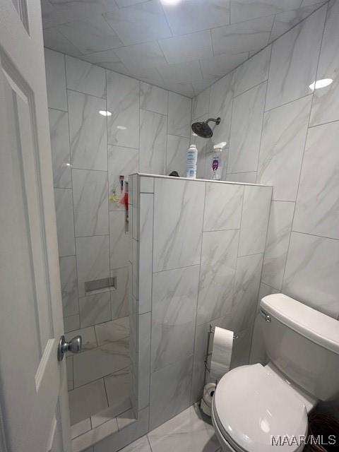 124 Reid Cir, Deatsville, AL 36022 - bathroom featuring a tile shower and marble look tile flooring