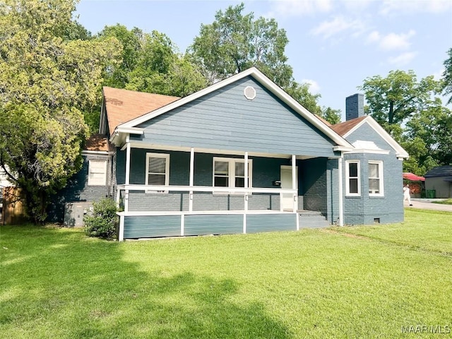 3155 Wilmington Rd, Montgomery, AL 36105 - back of house with a lawn, a chimney, covered porch, and brick siding