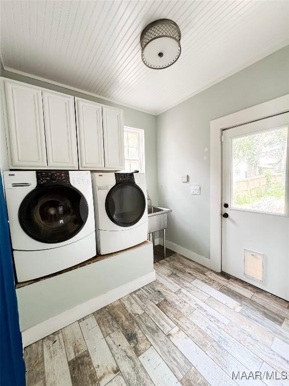 3155 Wilmington Rd, Montgomery, AL 36105 - laundry area featuring cabinet space, washing machine and dryer, and light wood-style flooring