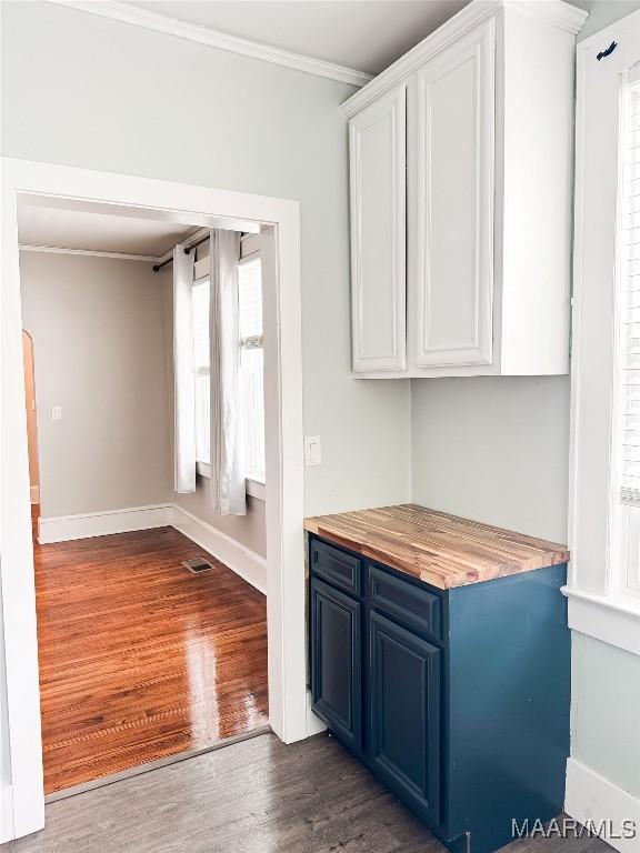 3155 Wilmington Rd, Montgomery, AL 36105 - kitchen with blue cabinetry, white cabinets, dark wood finished floors, and crown molding