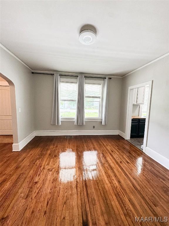 3155 Wilmington Rd, Montgomery, AL 36105 - unfurnished living room with arched walkways, wood finished floors, and ornamental molding