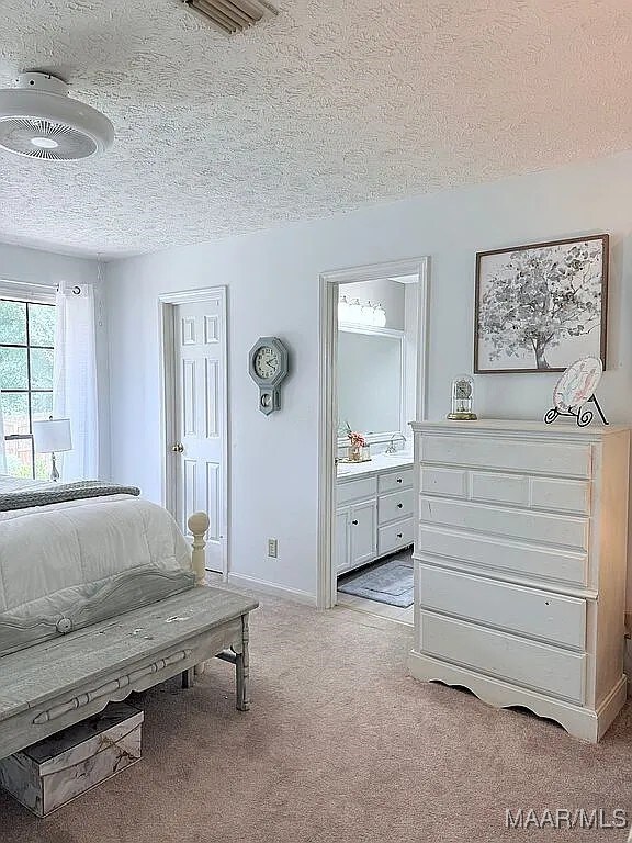 312 Rebekah Ln, Montgomery, AL 36109 - bedroom featuring a textured ceiling, carpet, and connected bathroom