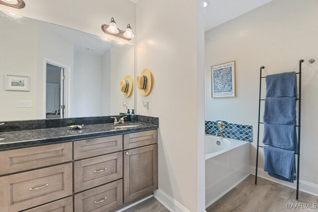 174 Shadow Wood Ln, Wetumpka, AL 36092 - full bathroom featuring wood finished floors, double vanity, and a garden tub