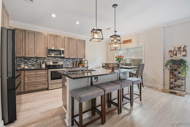 174 Shadow Wood Ln, Wetumpka, AL 36092 - kitchen featuring appliances with stainless steel finishes, dark countertops, backsplash, ornamental molding, and a kitchen bar