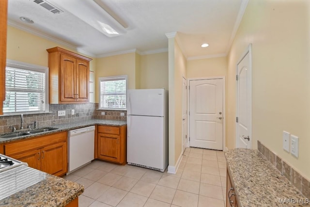 2196 N Ann Ave, Tallassee, AL 36078 - kitchen with white appliances, crown molding, brown cabinetry, tasteful backsplash, and light tile patterned floors