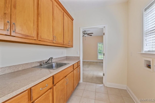 2196 N Ann Ave, Tallassee, AL 36078 - kitchen featuring light countertops, light tile patterned floors, ceiling fan, and brown cabinets