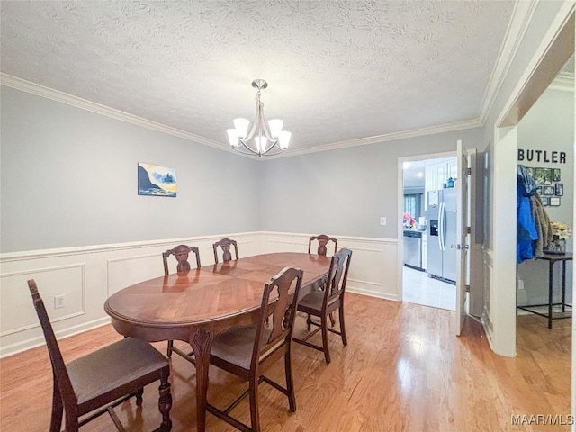 7908 Arrowhead Forest Ct, Montgomery, AL 36117 - dining room featuring a chandelier, light wood-style floors, ornamental molding, wainscoting, and a textured ceiling