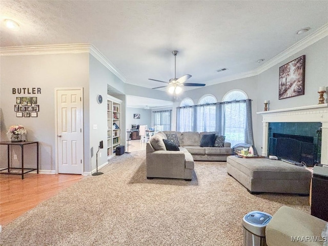 7908 Arrowhead Forest Ct, Montgomery, AL 36117 - living area featuring ornamental molding, built in shelves, ceiling fan, wood finished floors, and a tile fireplace