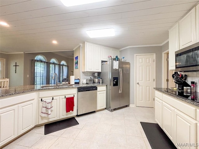7908 Arrowhead Forest Ct, Montgomery, AL 36117 - kitchen featuring stainless steel appliances, ornamental molding, backsplash, dark stone counters, and white cabinetry