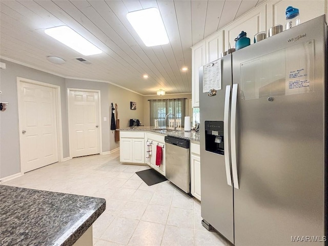 7908 Arrowhead Forest Ct, Montgomery, AL 36117 - kitchen with appliances with stainless steel finishes, white cabinets, a peninsula, recessed lighting, and light tile patterned floors