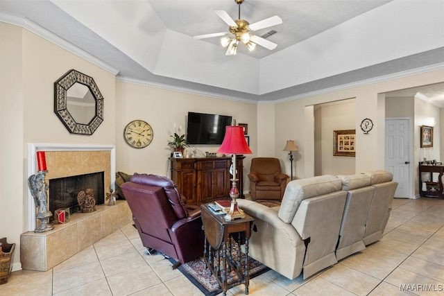8872 Old Magnolia Way, Montgomery, AL 36116 - living room featuring light tile patterned floors, a ceiling fan, a fireplace, a tray ceiling, and ornamental molding