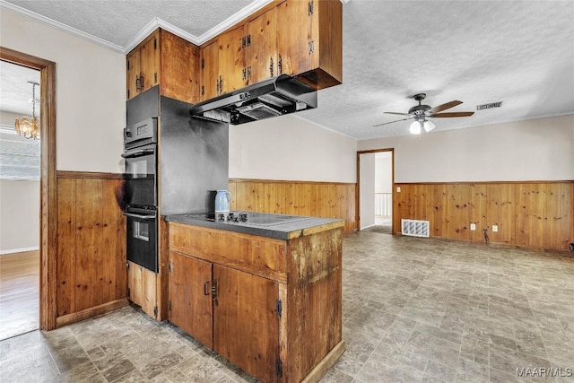 1422 Flamingo Ln, Montgomery, AL 36116 - kitchen featuring electric cooktop, wood walls, a textured ceiling, under cabinet range hood, and a wainscoted wall