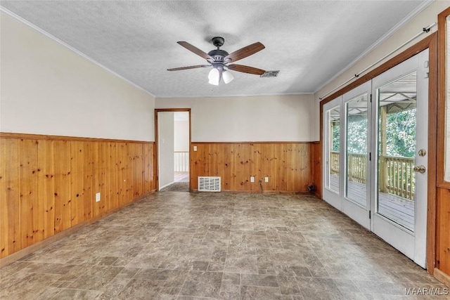 1422 Flamingo Ln, Montgomery, AL 36116 - spare room with stone finish floors, wainscoting, wood walls, a ceiling fan, and a textured ceiling