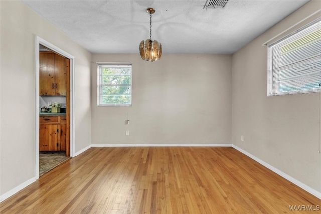 1422 Flamingo Ln, Montgomery, AL 36116 - unfurnished dining area featuring light wood-type flooring, a chandelier, and a textured ceiling