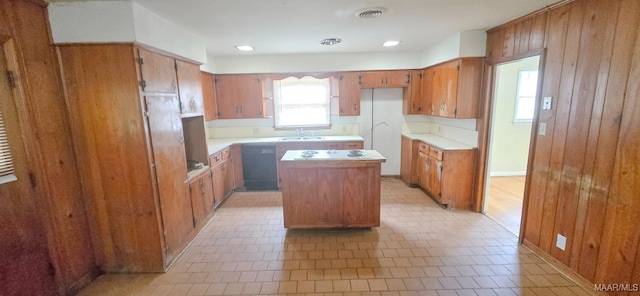 2804 Sumter Ave, Montgomery, AL 36109 - kitchen featuring brown cabinetry, a kitchen island, black dishwasher, light countertops, and white cooktop