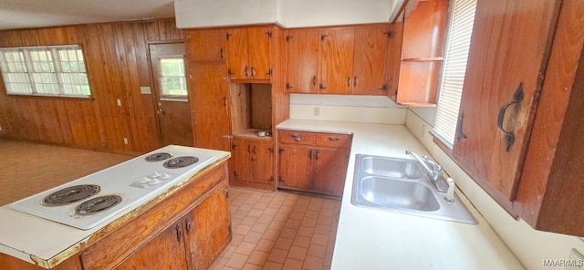 2804 Sumter Ave, Montgomery, AL 36109 - kitchen featuring wooden walls, brown cabinets, white electric stovetop, light countertops, and brick patterned floors