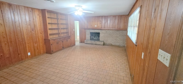 2804 Sumter Ave, Montgomery, AL 36109 - unfurnished living room featuring wood walls, a brick fireplace, and a ceiling fan