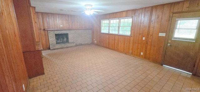 2804 Sumter Ave, Montgomery, AL 36109 - unfurnished living room with ceiling fan, plenty of natural light, wood walls, and a brick fireplace