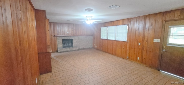 2804 Sumter Ave, Montgomery, AL 36109 - unfurnished living room featuring a ceiling fan, wood walls, and a brick fireplace