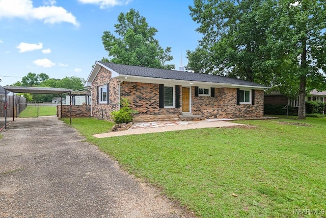 506 Lilly Ave, Tallassee, AL 36078 - single story home featuring asphalt driveway, brick siding, and a detached carport