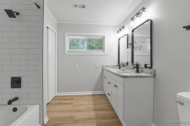 506 Lilly Ave, Tallassee, AL 36078 - bathroom with double vanity, ornamental molding,  shower combination, wood finished floors, and a textured ceiling