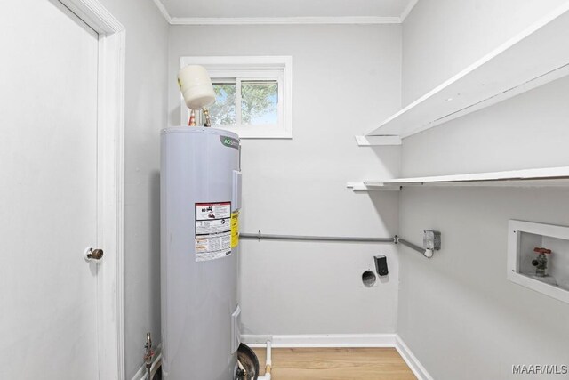 506 Lilly Ave, Tallassee, AL 36078 - laundry area featuring water heater, electric dryer hookup, hookup for a washing machine, crown molding, and wood finished floors