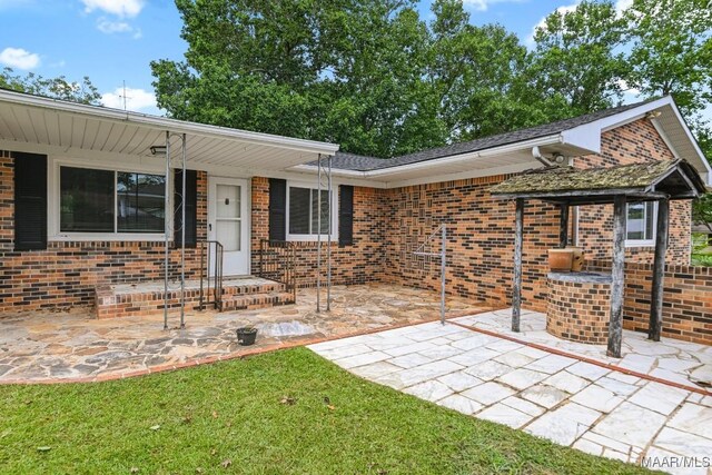 506 Lilly Ave, Tallassee, AL 36078 - view of front facade with brick siding and a patio area
