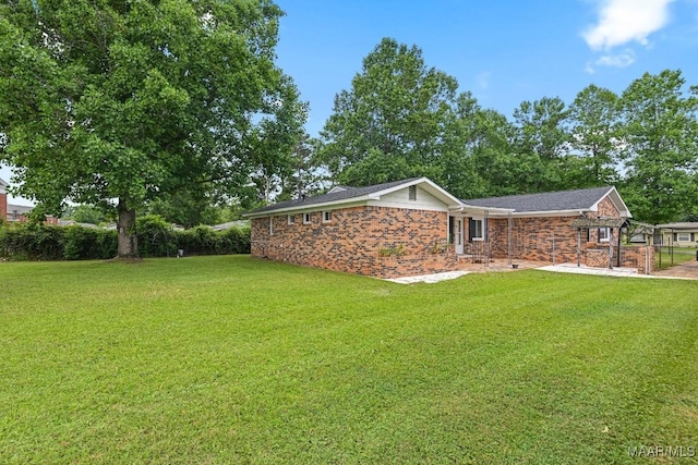 506 Lilly Ave, Tallassee, AL 36078 - rear view of house with a lawn and brick siding