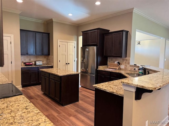 3701 Weston Pl, Montgomery, AL 36116 - kitchen with stainless steel fridge with ice dispenser, wood finished floors, light stone counters, dark brown cabinetry, and recessed lighting